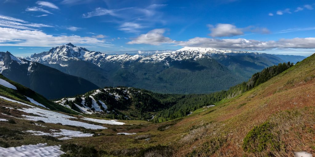 Overview of the meadow of knolls of goat mountain, with Baker hiding behind the clouds.