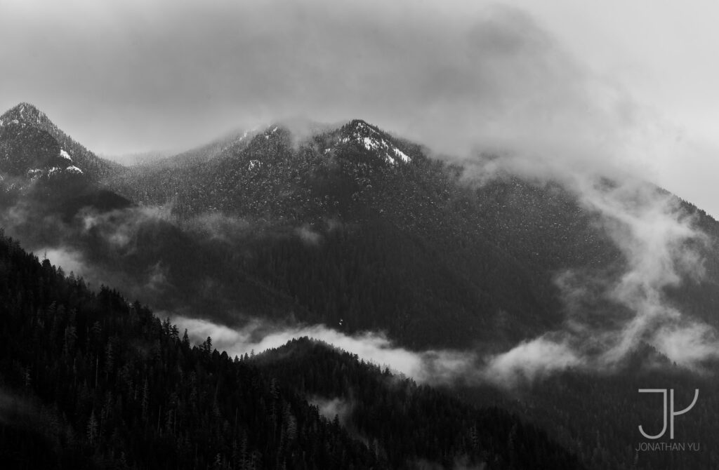 Clouds dance around low hanging peaks, leaving the seasons first snow