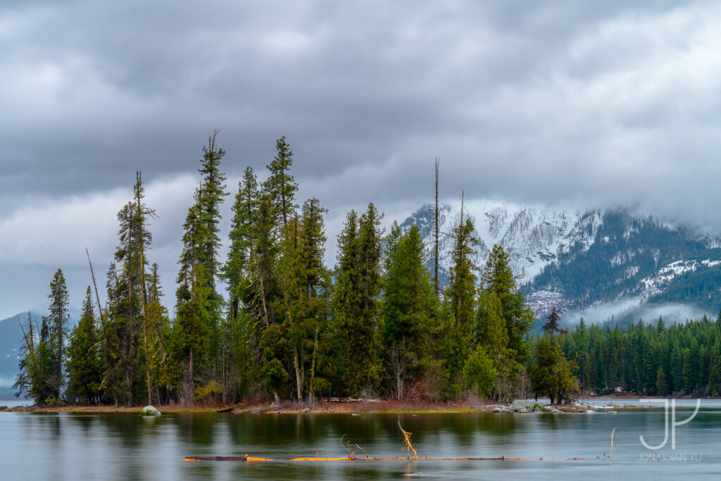 An island of peace surrounded by stormy clouds and snowy peaks