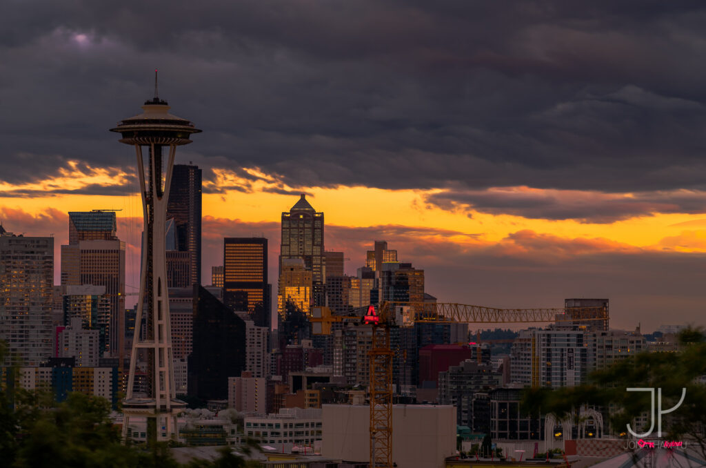 Fiery sunset mixed among concrete, steel, and lots of cranes